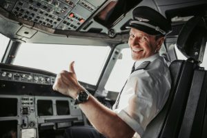 Man in uniform showing ok gesture stock photo. Airways concept